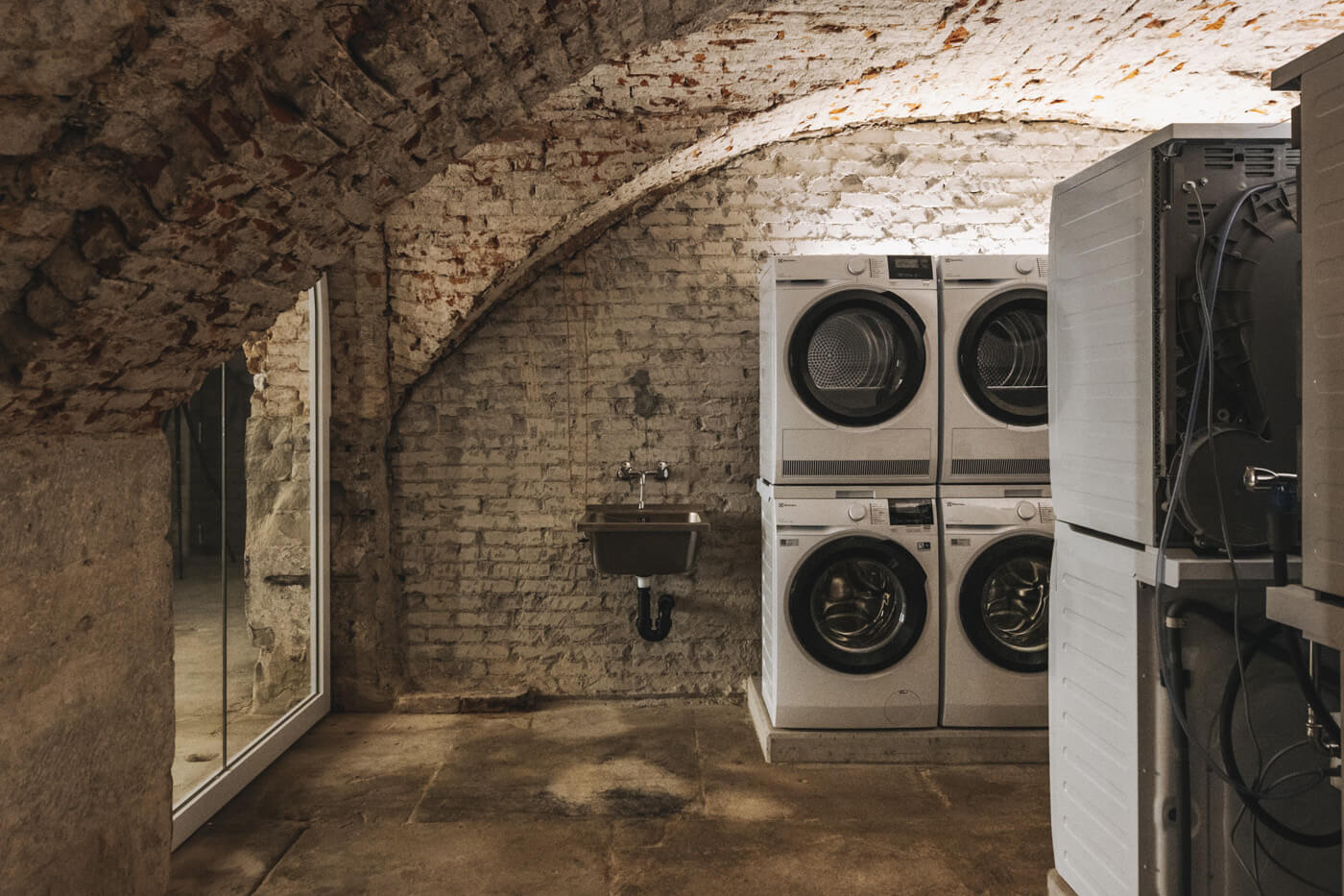 The laundry salon in the vaulted cellar, housing 17 individual Electrolux washing towers.